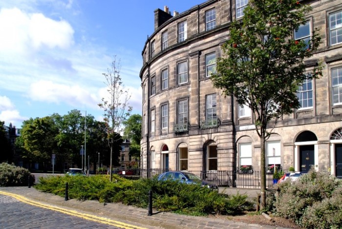 Holiday Accommodation apartment in a Georgian block with a cobbled street and shrubs in the foreground