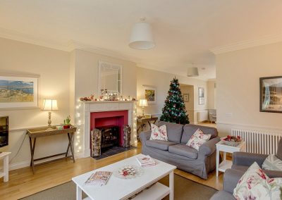 Sitting room in Garden Cottage with Christmas tree and festive decorations on the mantel piece