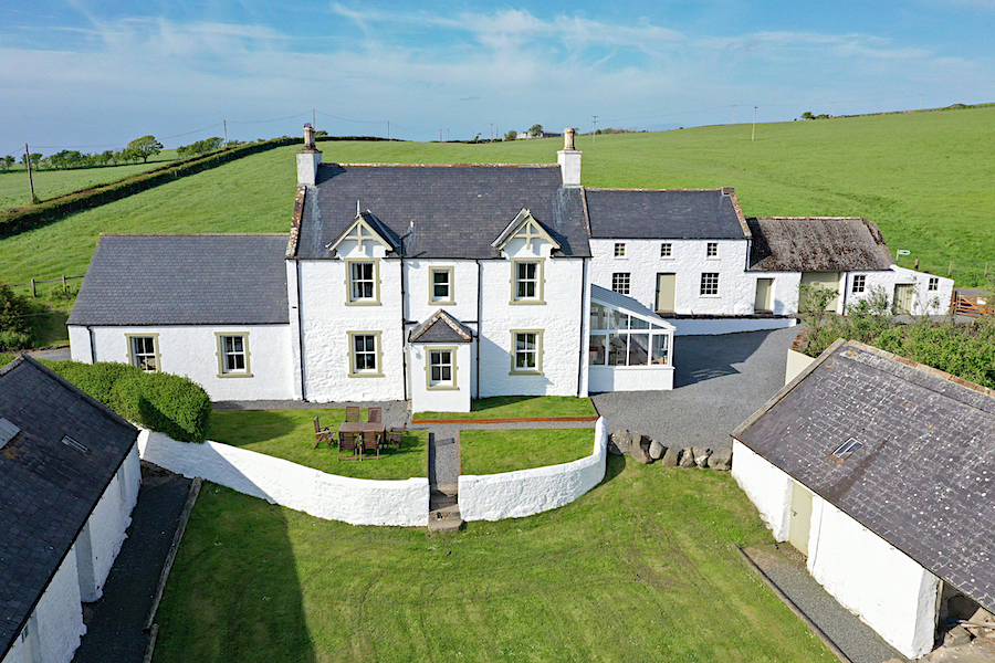 Pretty white farmhouse surrounded by rolling farm land